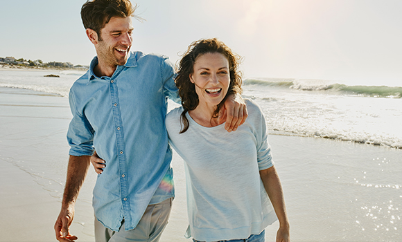 Happy couple walking on beach