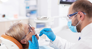 Dentist in mask doing dental exam