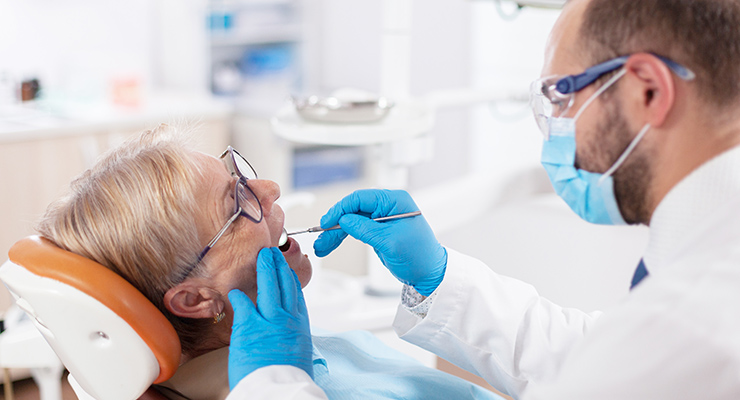 Dentist in mask doing dental exam